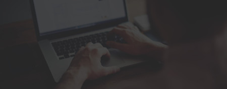 man typing on laptop while watching scorm player video